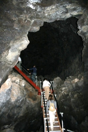 Students walking up a ladder into a cave